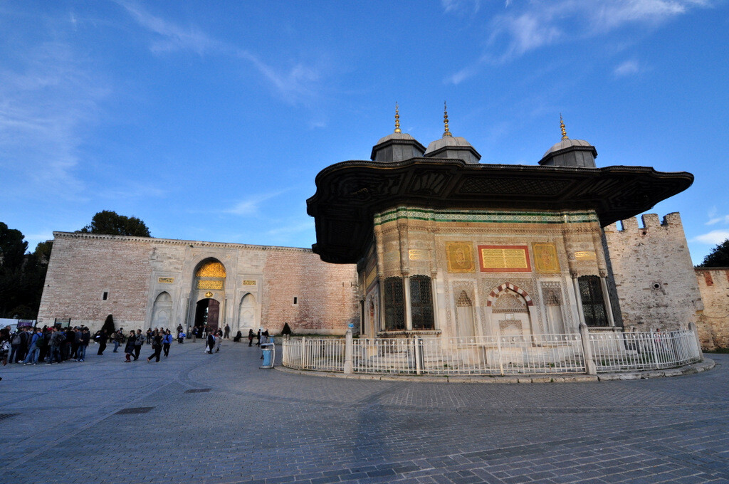 Wide-angle view of the Imperial Gate (Bâb-ı Hümâyûn) at the entrance of Topkapi Palace and the Fountain of Ahmed III, a symbol of the Ottoman Tulip Era. photo by Serhat Engul