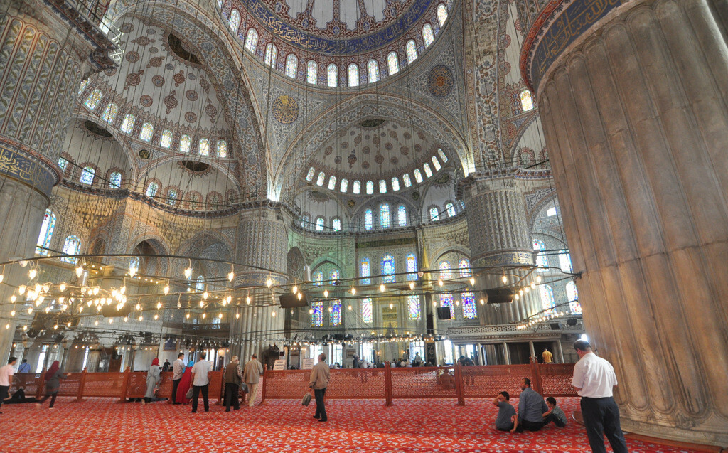 Excited visitors admiring the blue Iznik tiles, elephant-leg columns, and intricate ceiling details inside the Blue Mosque. photo by Serhat Engul