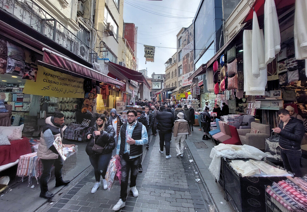 Crowds of local shoppers moving uphill along Mahmutpaşa Street near the Spice Bazaar, surrounded by dozens of budget clothing and local retail shops. photo by Serhat Engul
